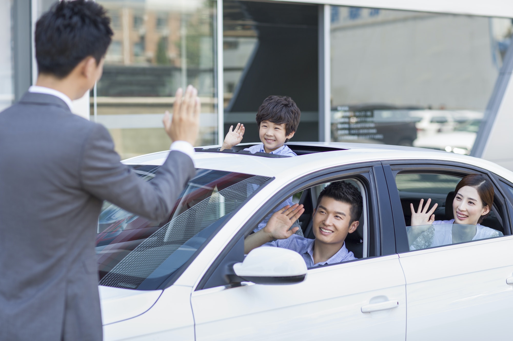 Jeune famille achetant une voiture