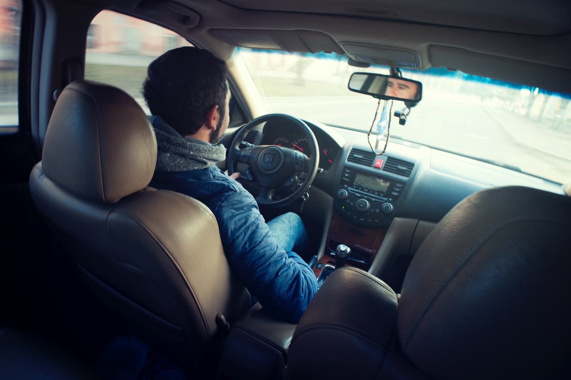 Homme Portant Une Veste Bleue Assis à L'intérieur D'une Voiture Pendant La Conduite