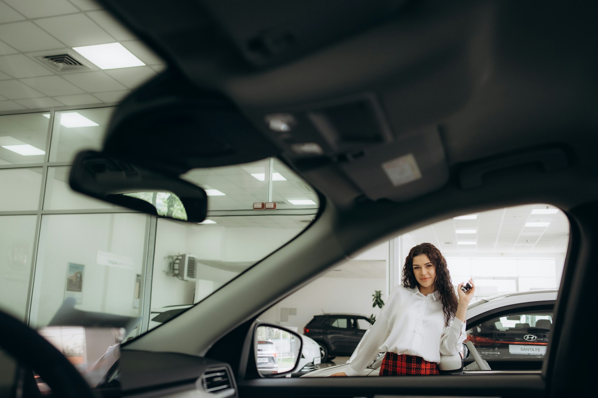 une belle femme cherche une voiture chez un concessionnaire automobile.