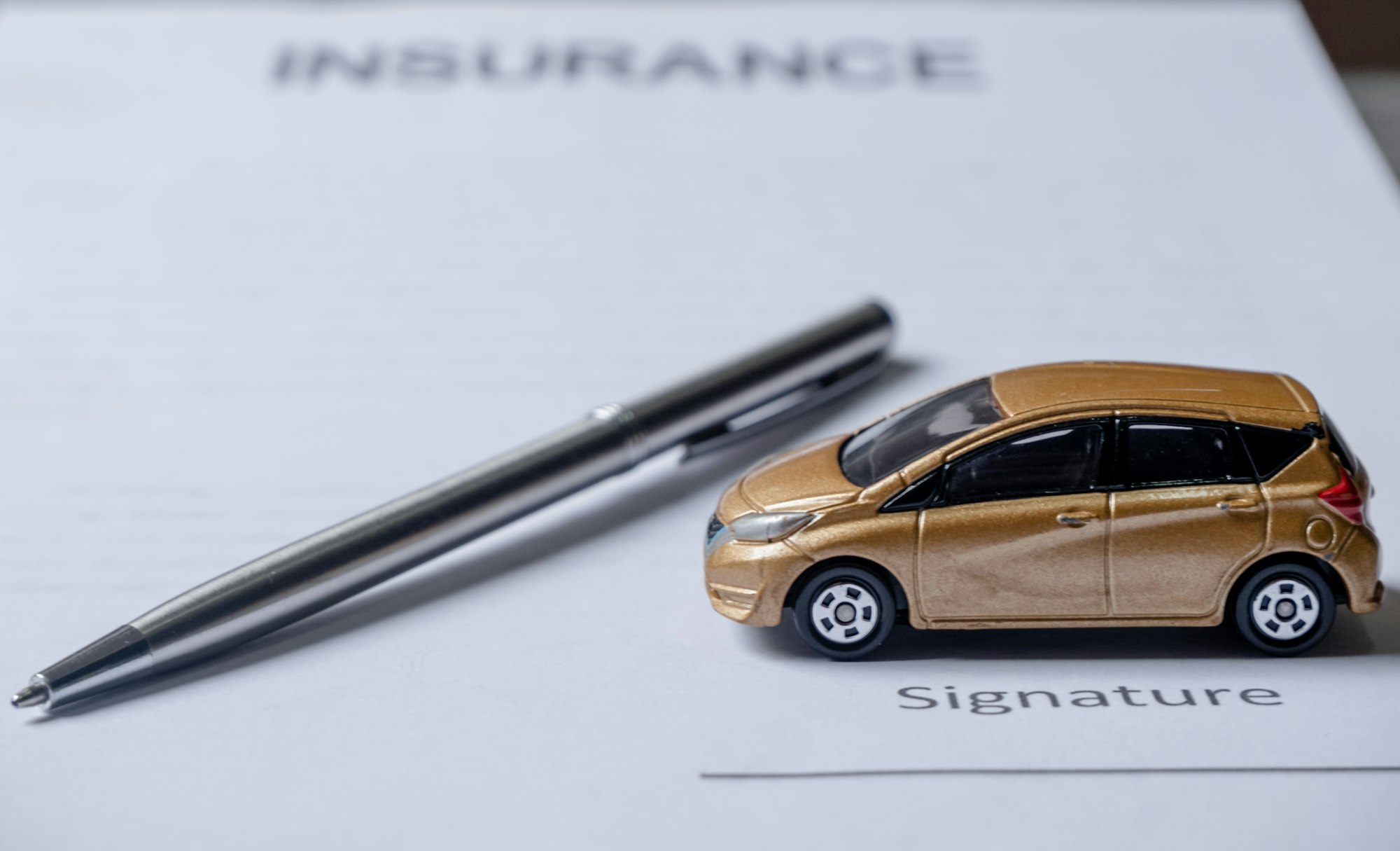 Voiture et stylo sur les documents d'assurance.