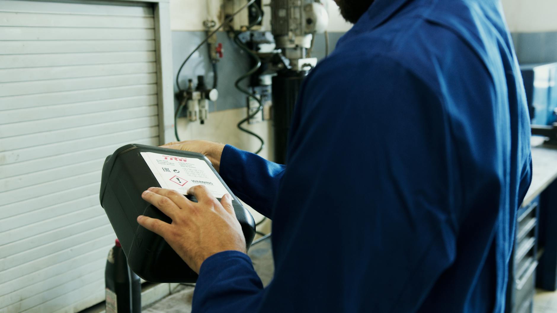 Mécanique utilisant l'outil de diagnostic pour inspecter le véhicule dans un atelier automobile.