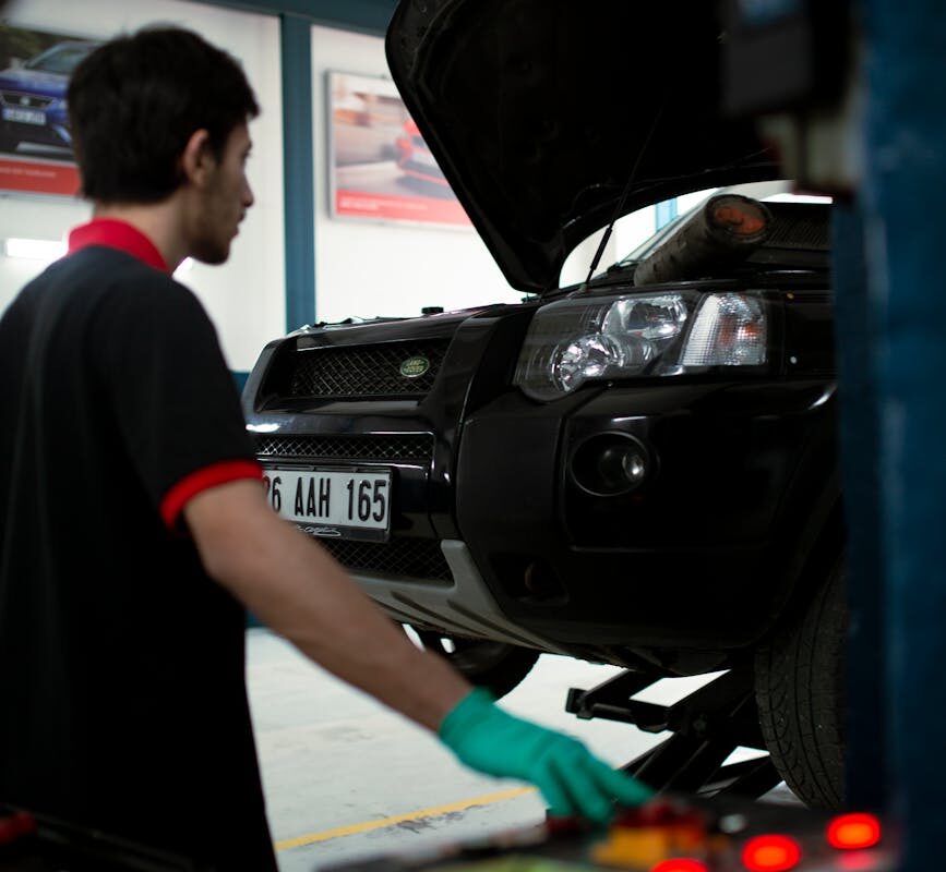Mécanique utilisant l'équipement pour élever le SUV pour inspection dans un garage automobile.