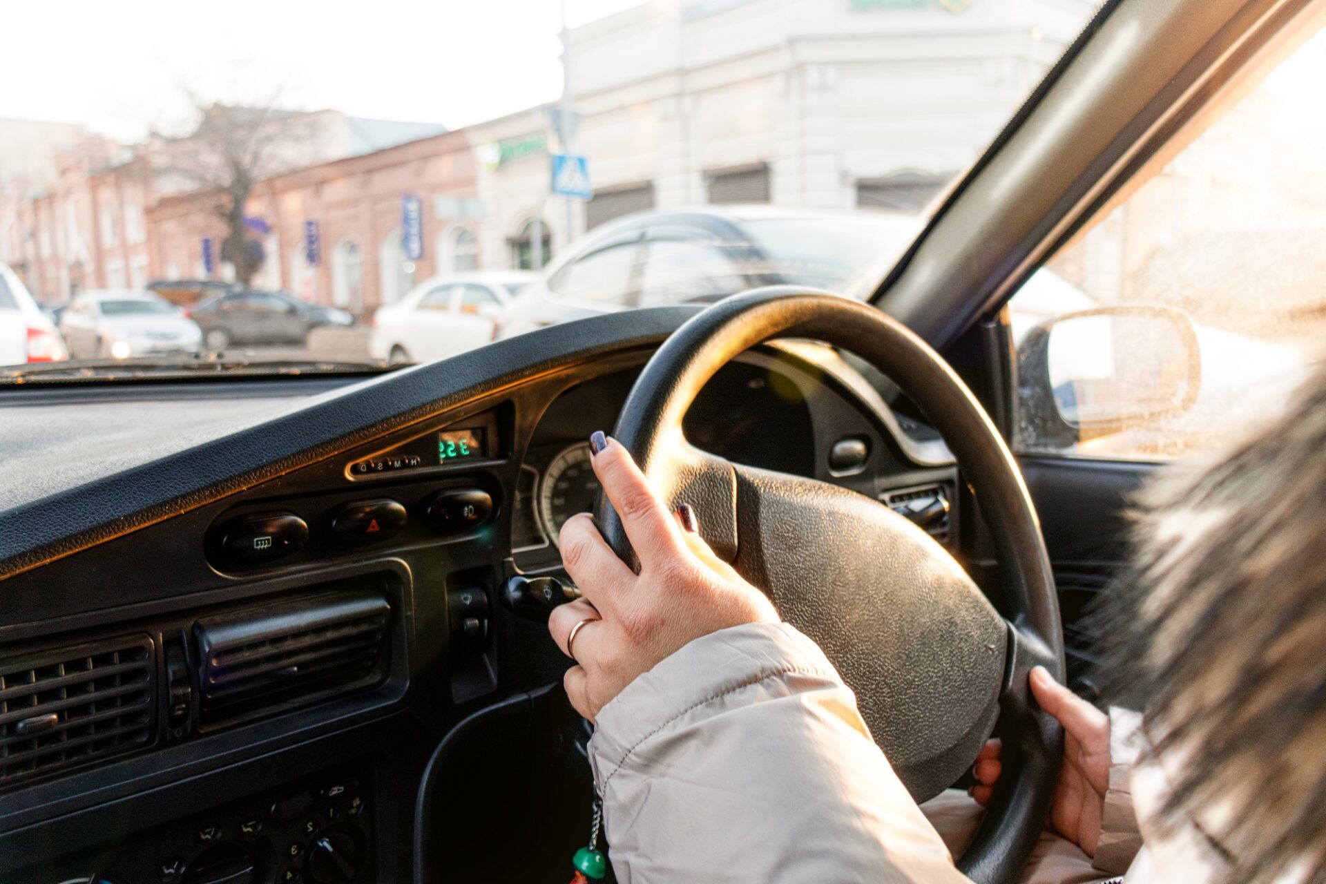 Les mains féminines tiennent le volant d'une voiture et la conduisent.
