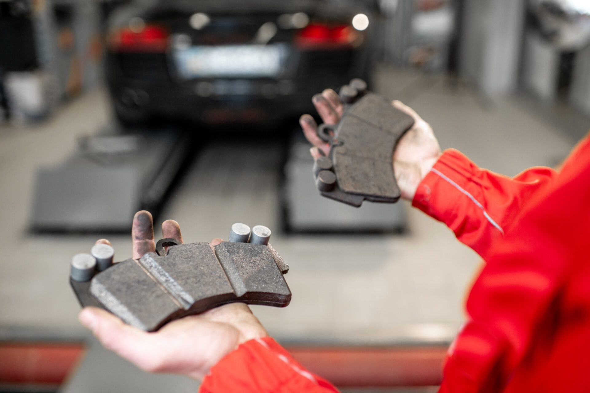 Mécanique automatique tenant des plaquettes de frein neuves et d'occasion au service de la voiture, vue grossière