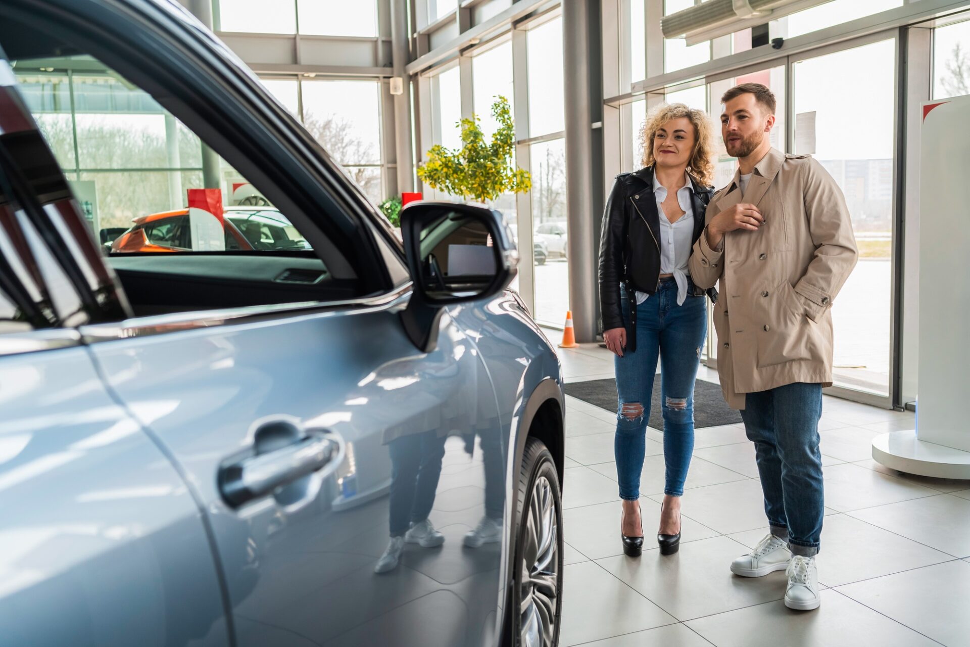 Beau couple dans le concessionnaire automobile choisit la voiture