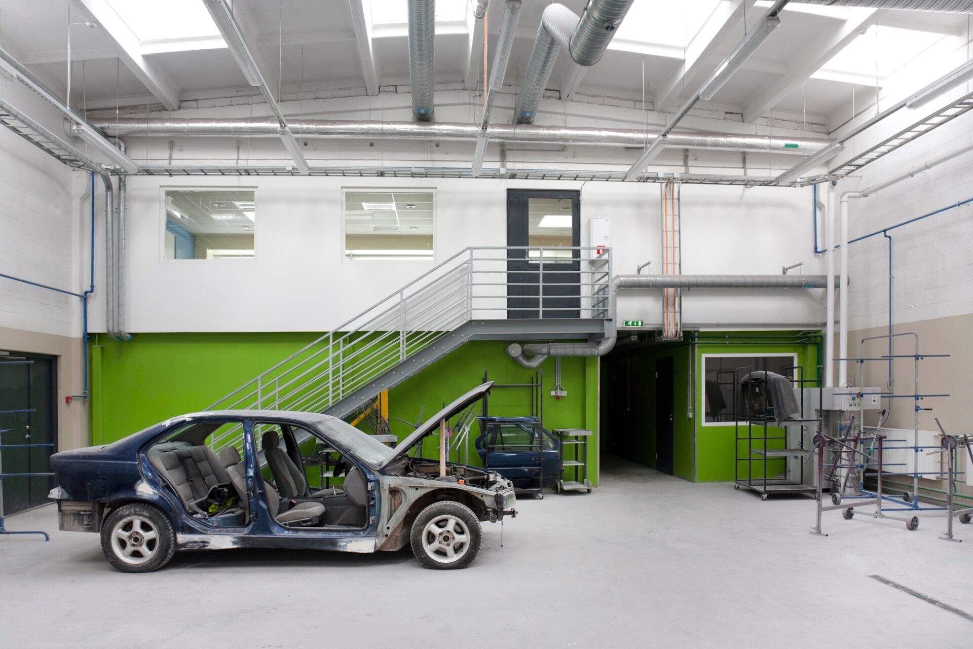 Une vieille voiture avec le capot dans un garage de réparation.