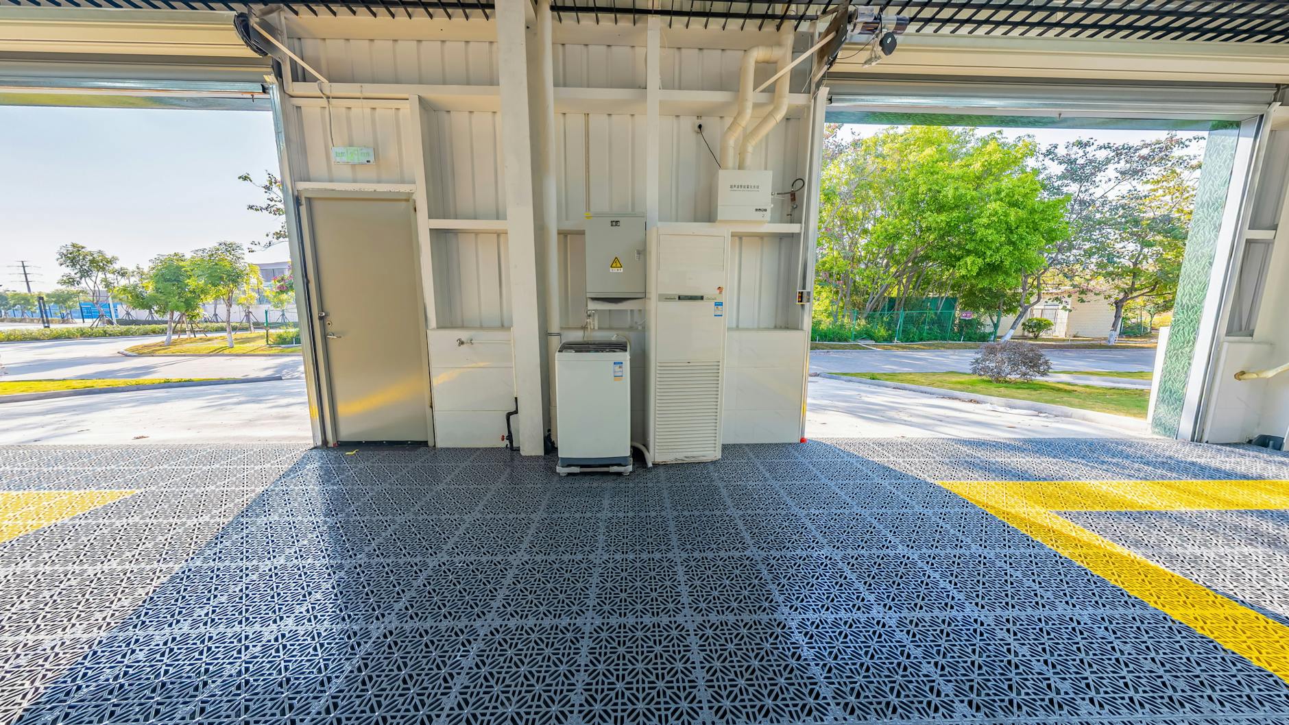 Garage ouvert spacieux avec revêtement de sol en grille métallique durable et configuration des équipements orientée vers l'extérieur.